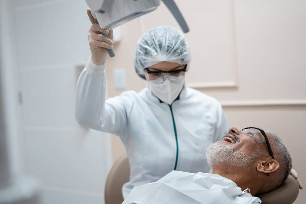 a man in a dental chair is prepared for a procedure