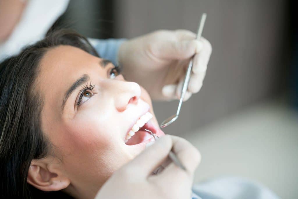 a dentist cleans a woman's teeth