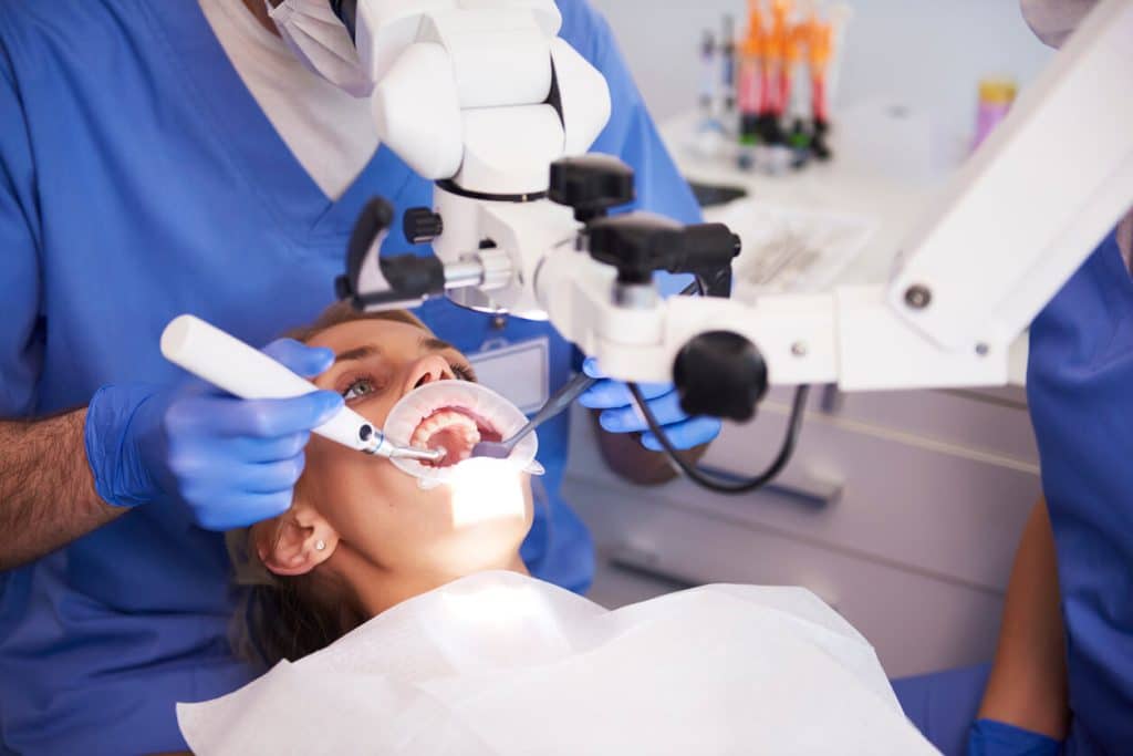 Young Woman In Dentist Chair Getting A Root Canal