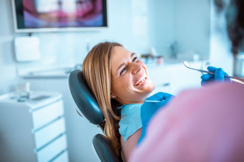 a woman in a dental chair smiles